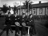 Grupp fyra pojkar. I bakgrunden Rubinska gården Kungsgatan i Lindesberg.