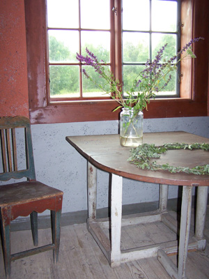 Interiör, bord och stol vid ett fönster.
